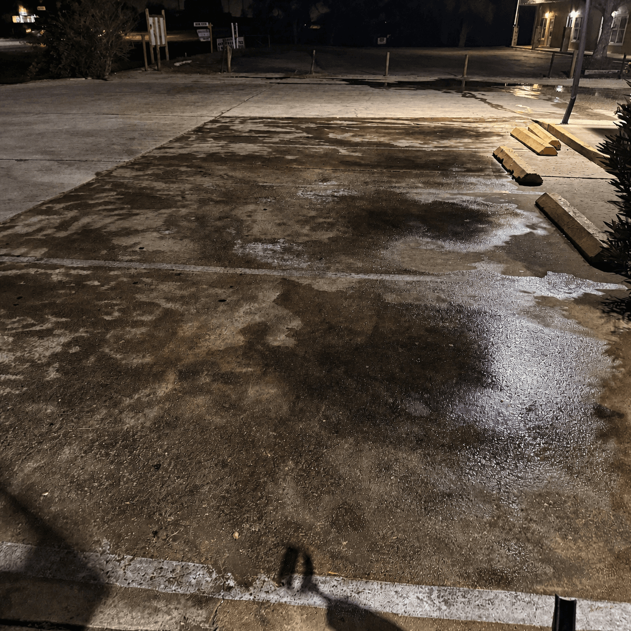 Commercial parking bay before Torres Pressure Washing — heavily stained concrete