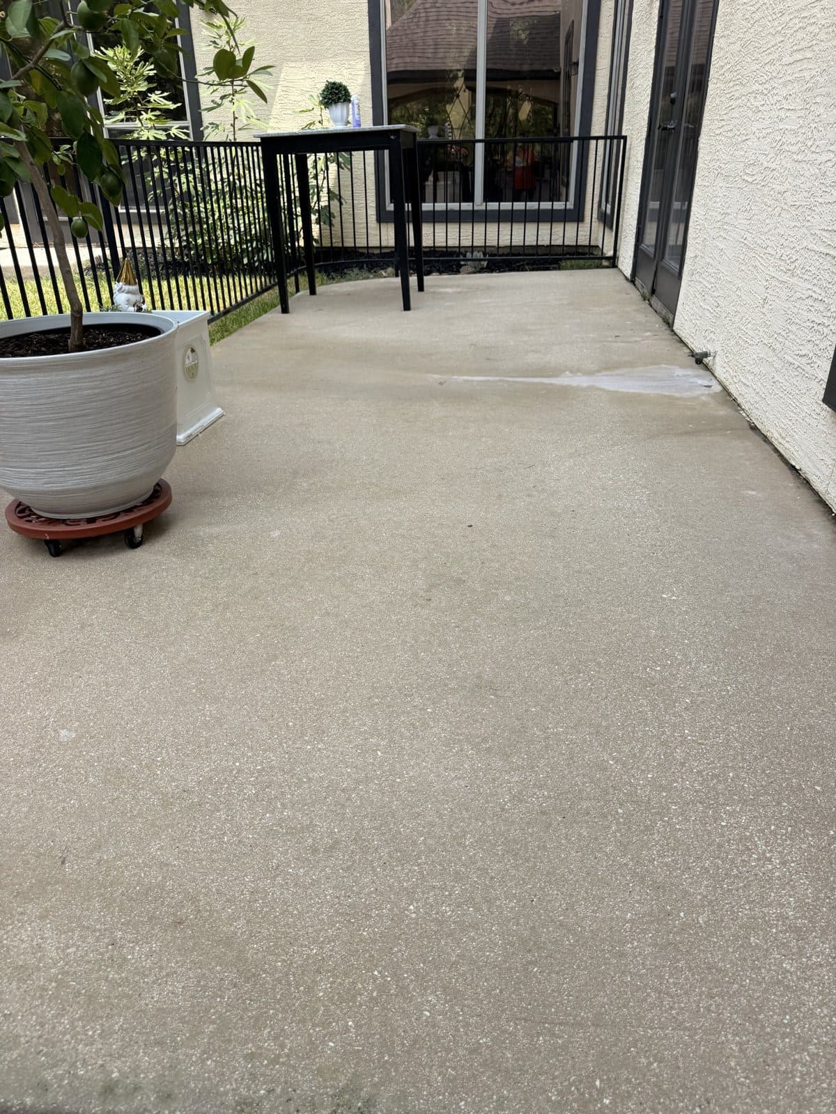 Finished residential patio after pressure washing, furniture back in place on clean concrete