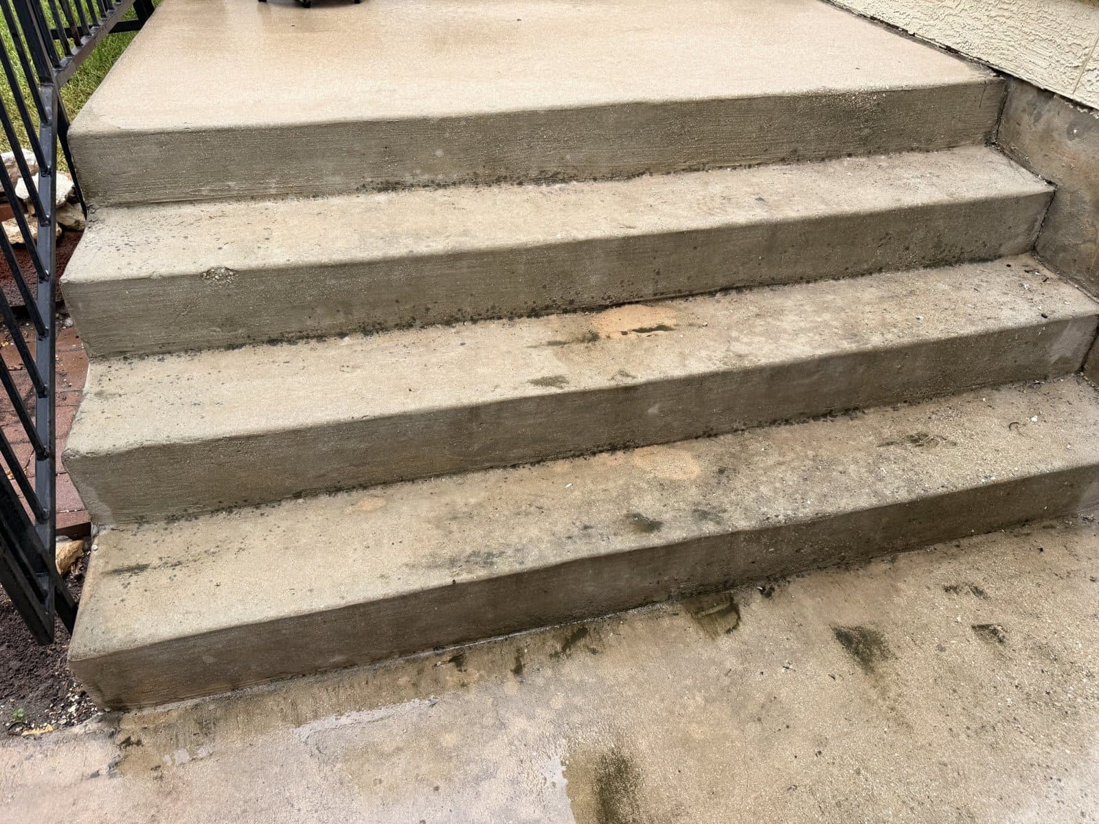 Concrete porch steps after pressure washing, clean and evenly toned