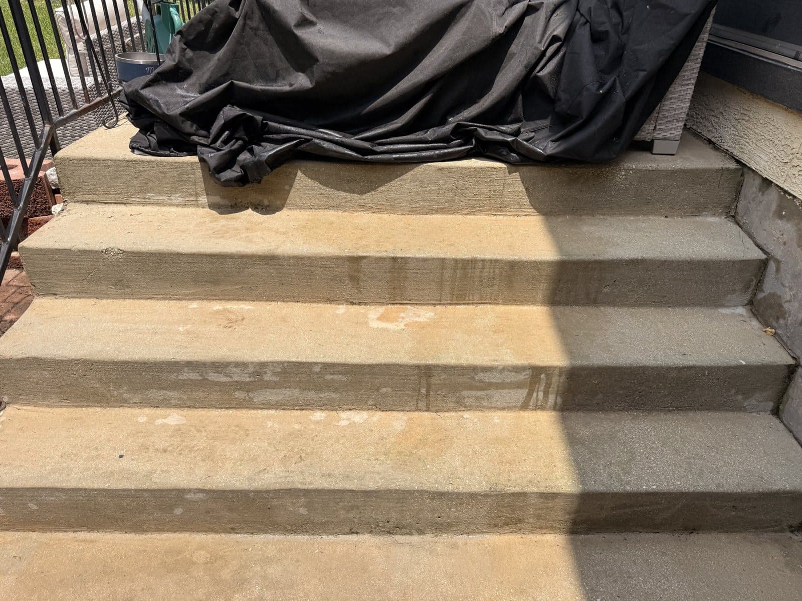 Close detail of cleaned concrete porch steps showing the restored surface texture