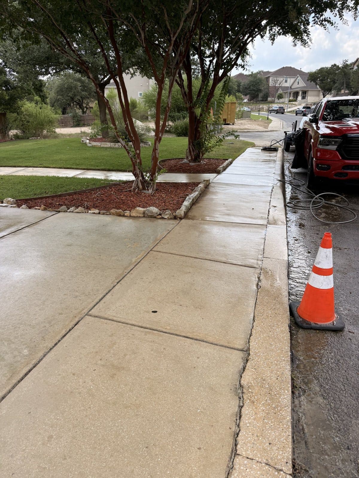 Front walkway after pressure washing, clean wet concrete leading out to the street